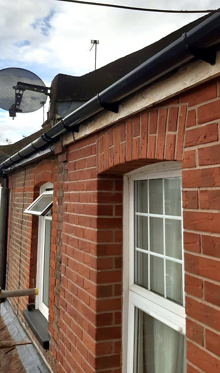 Red brick slips with a new black gutter on a rear extension