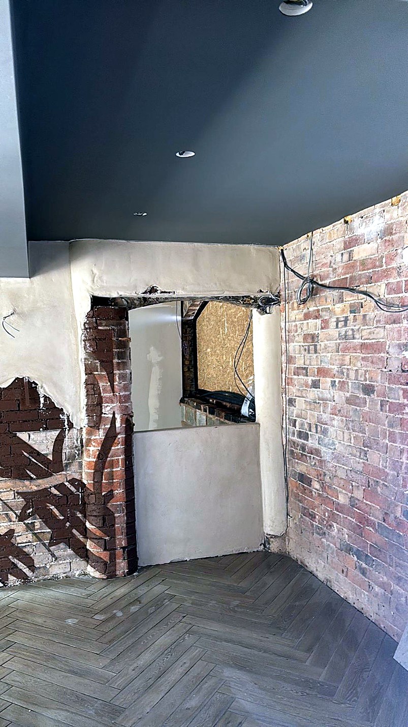 Commercial interior with exposed brick, plaster and herringbone floor